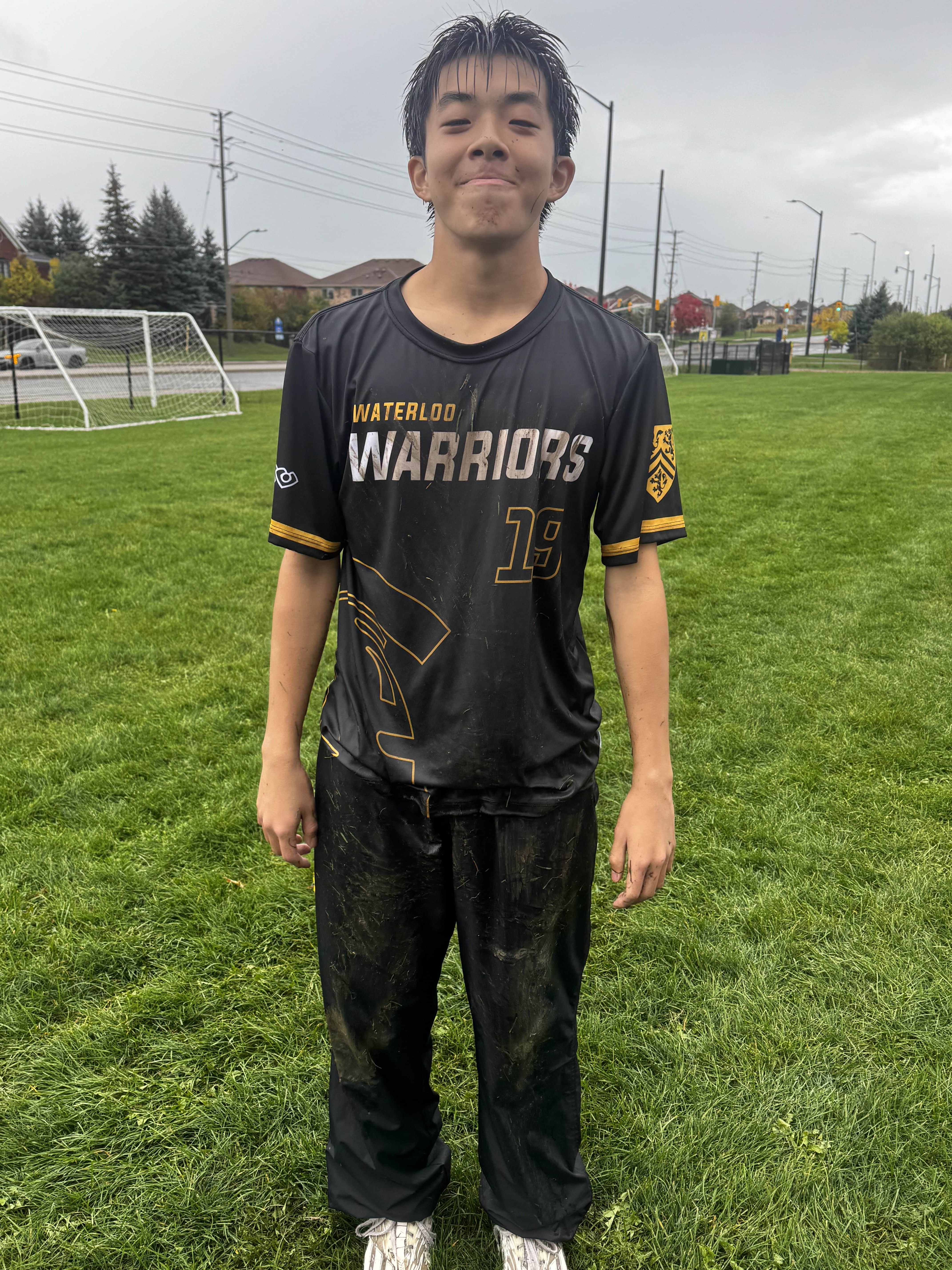 Standing on the field in a mud-covered Waterloo Warriors kit